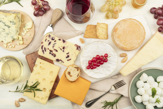 Various types of cheese with wine on a light background