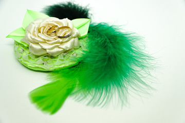 wedding rings in rose made by hands with green feathers on white background