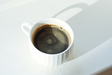 Cup of fresh coffee on a Sunny windowsill  