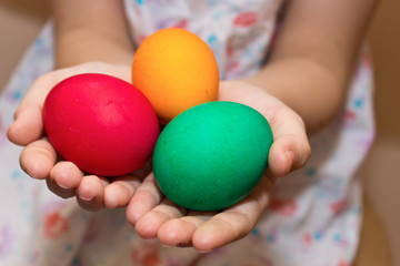 Fototapeta na wymiar Child hold colorful painted Easter eggs in his hands.