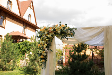 A part of beautiful wedding arch with fresh white flowers and greenery in the garden