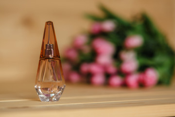 Bouquet of pink tulips and perfume with a beautiful bow on a wooden background