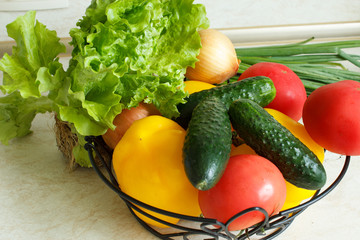 Organic vegetables in a basket on the kitchen table. Close-up.