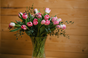 A bouquet of pink tulips in a beautiful crystal vase