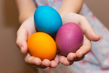 Child hold colorful painted Easter eggs in his hands.