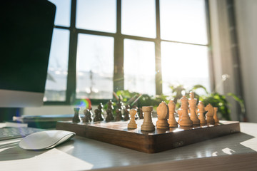 traditional chess board on workplace against sunshine