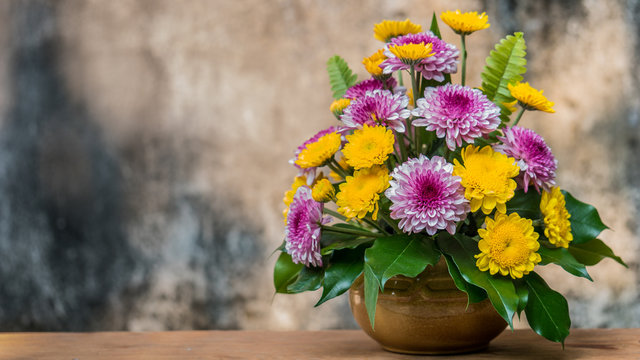 Chrysanthemum flower in a vase on wooden table