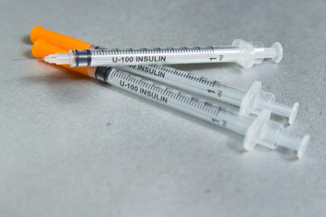 Insulin syringe on gray background.