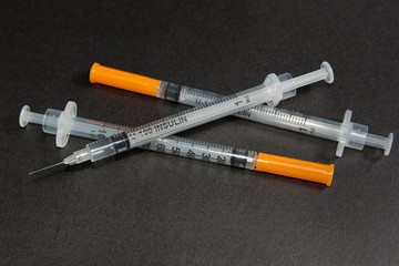 Insulin syringe on a black background.