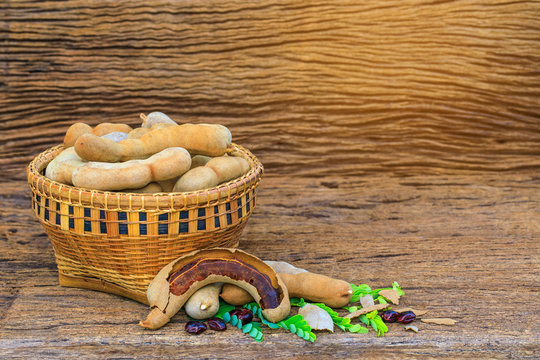 Tamarind in the bamboo basket  on wooden background.