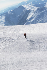 Fototapeta na wymiar Silhouette of skier downhill on snowy slope