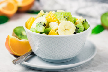 Winter fruit salad with maple lime dressing on white background. Selective focus, copy space. 