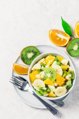 Honey lime dressing fruit salad on white background. Top view, copy space.