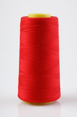 bobbin with red thread on a white background