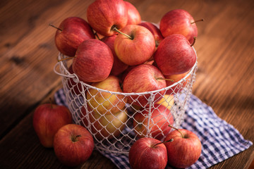 backet full of apples on wood table background 