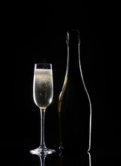 Silhouette champagne. Champagne pouring into glass on black background