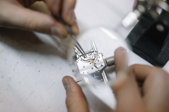 Close up of watchmaker repair clockwork under magnifier