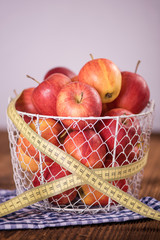apple diet weight loss concept apples in basket with tape measure 