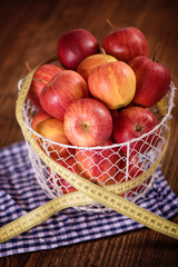 apple diet weight loss concept apples in basket with tape measure 