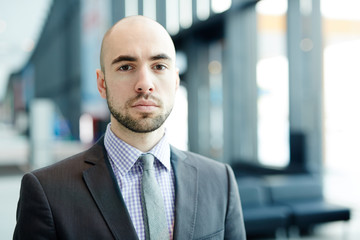 Naklejka premium Young business traveler in suit and tie looking at camera in airport