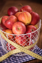apple diet weight loss concept apples in basket with tape measure 