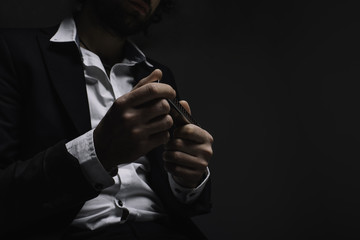 cropped shot of musician in suit holding harmonica on black - obrazy, fototapety, plakaty