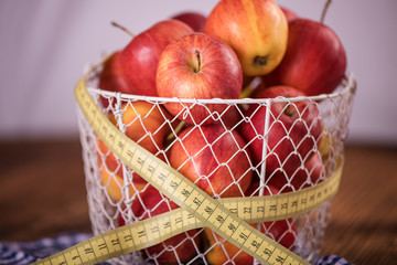 apple diet weight loss concept apples in basket with tape measure 