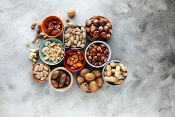 mixed nuts on grey background. Healthy food and snack. Walnut, pecan, almonds, hazelnuts and cashews.
