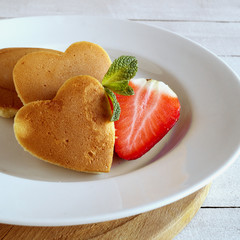 Pancakes in the shape of a heart with berries.