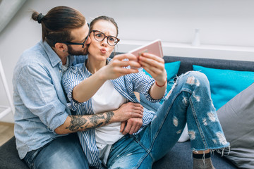 Young couple taking selfie at home 