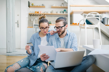 Young couple paying bills with credit card 