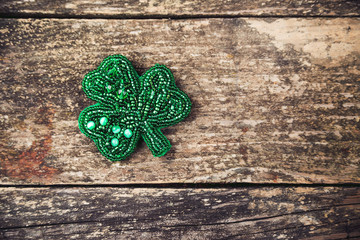 brooch in the form of clover on rustic wooden background