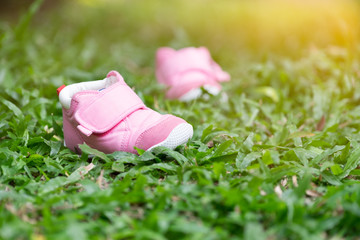 Baby shoes in pink at the lawn.