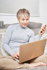 Seniorin mit Laptop Computer online
