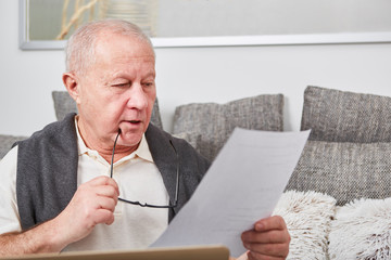 Senior als Rentner liest Unterlagen