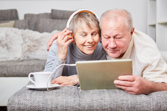 Senioren Paar mit Tablet PC hört Musik