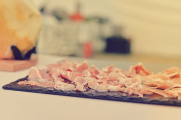 Naklejka na ściany i meble Prosciutto or jamon serrano. Close up on cutting traditional Italian Spanish ham. Slicing prepared hamon gastronomy background