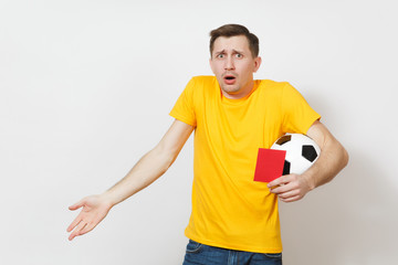 European sad upset crying shocked young man, football fan or player in yellow uniform hold in hand red soccer card for retire from field isolated on white background. Sport play, lifestyle concept.