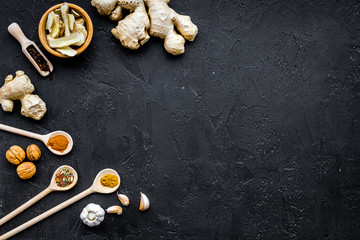Condiments, seasoning and spices concept. Dry spices in wooden spoons on black background top view copy space