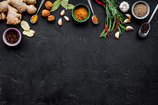 Gastronomy, culinary. Secrets of tasty dishes. Seasoning and spices. Rosemary, ginger, chili pepper on black background top view copy space