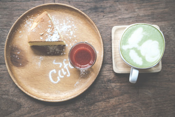 cheesecake with strawberry sauce topping & icing sugar. hot matcha green tea drink latte with milk topping in white mug