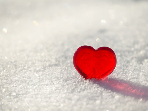 Red heart on a white snow.