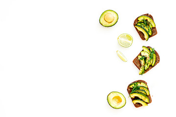 Snacks with avocado. Avocado toast with rye bread on white background top view copy space