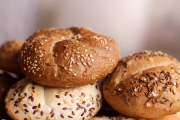 Tasty freshly baked butter kaiser roll with linseed and sunflower seeds. Top view, copy space, selective focus. Pastries on a wooden table. Blurred background. Concept of fresh pastry.