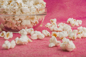 popcorn in a glass plate, on a pink background