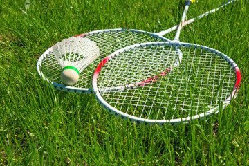 Rackets for playing badminton and a small cup on the grass close-up with a coryza space flat lay top view , the concept of active summer games
