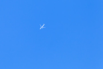White jet plane flies in sky