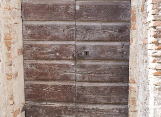 old wooden door in a medieval village, Italy