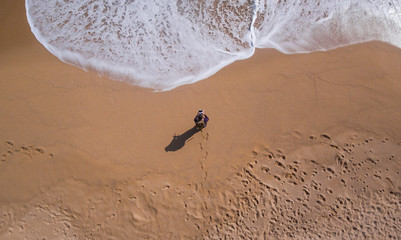 View aerial of a single beach where there is a person walking