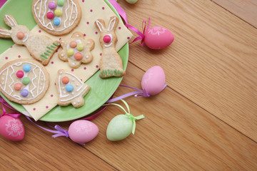 Fototapeta na wymiar Easter glazed cookies in shape of egg, bunny, flower and bell on wooden background